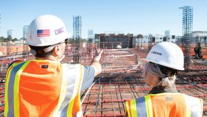 Two workers standing atop a building under construction